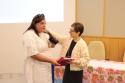 Chefe do LapClin Aids, Dra. Beatriz Grinsztejn, recebe homenagem da mãos da educadora comunitária, Laylla Monteiro. 