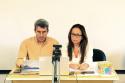 Foto com os dois professores e coordenadores do curso Saúde Única numa perspectiva Global. Da esquerda para direita, Dr. Rodrigo Menezes e Dra. Mayumi Wakimoto. Ambos estão sentados atrás de uma mesa, tendo a frente um laptop aberto e uma câmara de filmagem.