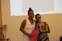 A pesquisadora do LapClin Aids, Dra. Emilia Jalil, recebe homenagem das mãos da educadora comunitária Taylla Vargas. 